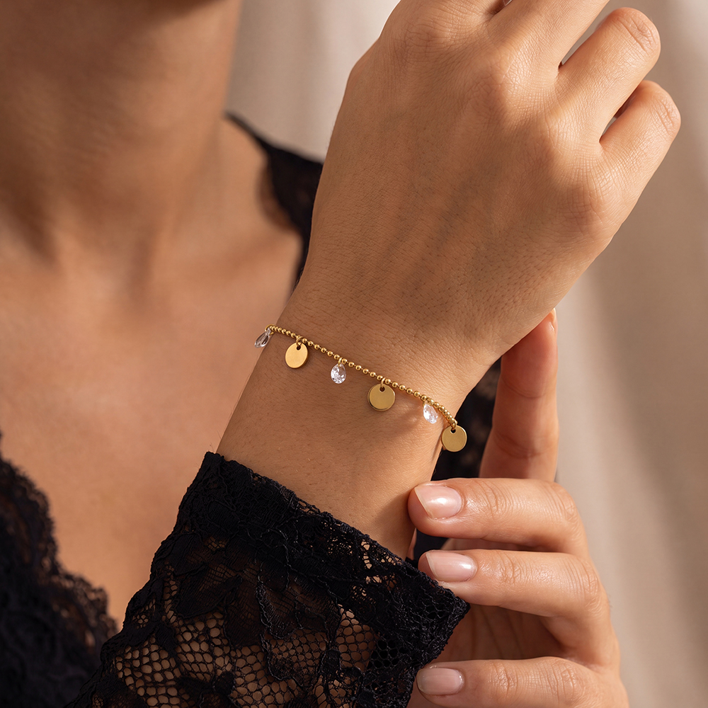 Stainless steel bracelet, 16 cm, with gold-coloured discs and cubic zirconia  